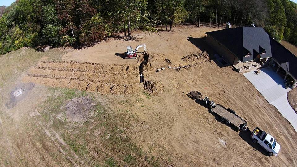 Aerial view of a residential septic system installation by Miller Septic, with trench lines dug beside a new home